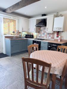 a kitchen with a table with chairs and a stove at Misty View - 2 Bed Cottage in Winchcombe in Winchcombe +25 photos