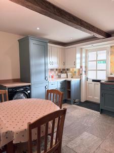 a kitchen with a table and a dining room at Misty View - 2 Bed Cottage in Winchcombe in Winchcombe