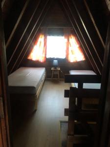 a attic room with two beds and a window at Joyosada - Ferienhäuser in Seenlandschaft in Prusim