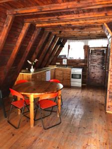 a kitchen with a wooden table and red chairs at Joyosada - Ferienhäuser in Seenlandschaft in Prusim