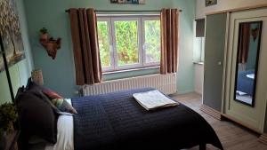a bedroom with a bed in front of a window at "En Aqualye" Appartement 2 personnes chez l'habitant in Aywaille