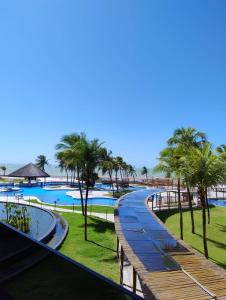 a walkway next to a swimming pool with palm trees at Hotel Pirâmides natal in Natal +5 photos