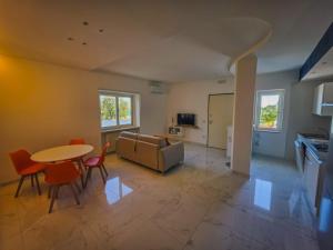 a living room with a couch and a table and chairs at Casa Zora - Vista Mare in Vieste