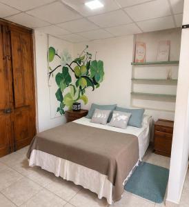 a bedroom with a bed with a plant on the wall at Hospedaje Don Felix in General Acha