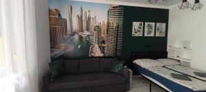 a bedroom with a couch and a poster of a city at Mérey Apartment in Szeged
