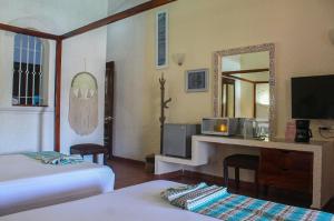 a hotel room with two beds and a mirror at Chez Waffle Hotel in Puerto Aventuras
