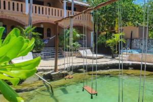 a group of swings in the water in front of a house at Chez Waffle Hotel in Puerto Aventuras