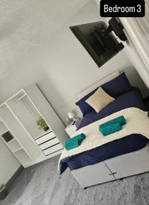 a bedroom with a bed with blue pillows and a tv at The Queens Hotel in Rhondda