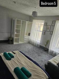a bedroom with a bed with green pillows on it at The Queens Hotel in Rhondda