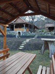 a pavilion with a picnic table and a building at Hidden Garden Kide (Chidea) in Cluj-Napoca