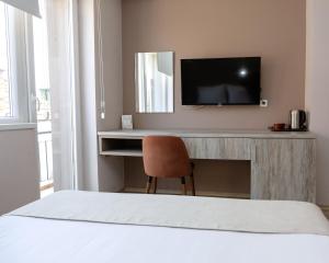 a bedroom with a desk with a television and a chair at ZARO Apartments in Bitola +42 photos
