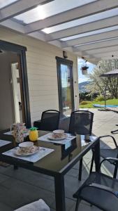 a table with plates and chairs on a patio at Slow Lake House Koszarka in Gródek Nad Dunajcem