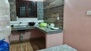 a bathroom with a counter with a sink and a mirror at Pink villa inn in Guwahati