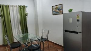 a dining room with a glass table and a refrigerator at Pink villa inn in Guwahati