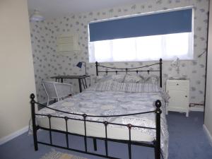 a bedroom with a bed and a window at Wisteria House in Blean