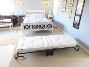 a bedroom with two beds and a couch in it at Wisteria House in Blean
