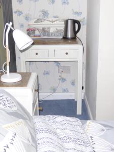 a white table with a pot on top of it in a bedroom at Wisteria House in Blean +3 photos