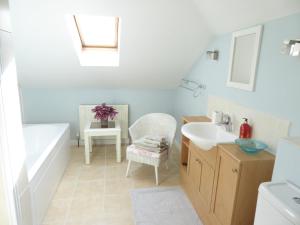 a bathroom with a tub and a sink and a bath tub at Wisteria House in Blean