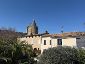 a building with a tower in the background at La Vade in Carcassonne