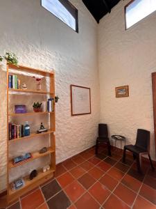 a room with a book shelf and a chair at Finca Hostal Ágora in Jardin