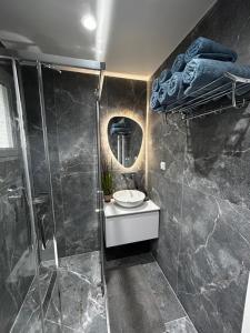 a bathroom with a shower and a sink and a mirror at Ksamil Apartament Sela in Ksamil +119 photos