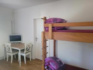 a bedroom with a desk and a bunk bed at Auberge des Fées in Buttes