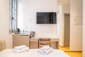 a bedroom with a desk and a tv on the wall at Epos by the Sea in Larnaca