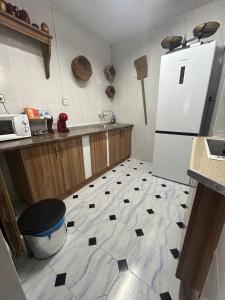 a kitchen with a black and white floor with a refrigerator at Casa Rincón in Iznatoraf +19 photos