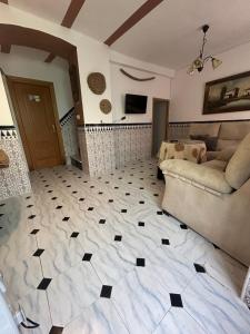 a living room with a couch and a tiled floor at Casa Rincón in Iznatoraf