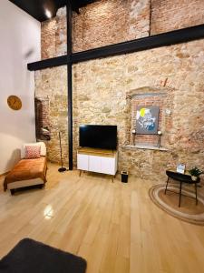 a living room with a television and a brick wall at San Felipe Loft in Panama City