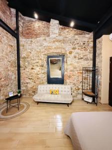 a living room with a white couch in a brick wall at San Felipe Loft in Panama City