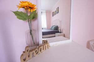 a mirror on a shelf with a vase with a flower in it at Apartment Sunflower021 in Novi Sad