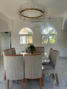 a dining room with a table and chairs and a chandelier at Quinta Pompella in San Salvador