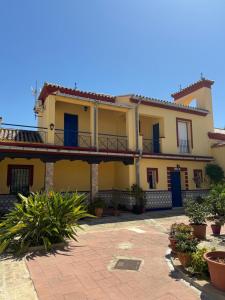 a yellow house with a balcony and some plants at Chalet Suizo in Arcos de la Frontera