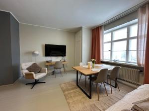 a living room with a table and chairs and a tv at Villa Karijoki in Karijoki