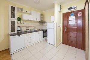 a kitchen with white appliances and a brown door at Apartment Sunflower021 in Novi Sad +13 photos