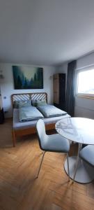 a room with two beds and a table and a window at Schwarzwaldstübchen "Altas Montañas" mit Schwimmbad in Baiersbronn +62 photos