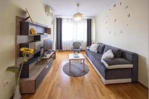 a living room with a couch and a table at Apartment Sunflower021 in Novi Sad