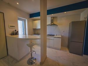 a large kitchen with a counter and a refrigerator at Casa Zora - Vista Mare in Vieste