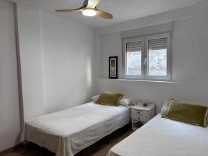 a bedroom with two beds and a ceiling fan at Les Coves de Lluna in Vall de Uxó