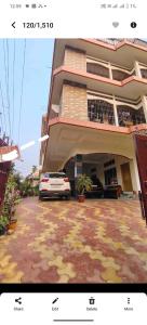 a building with a car parked in front of it at Pink villa inn in Guwahati
