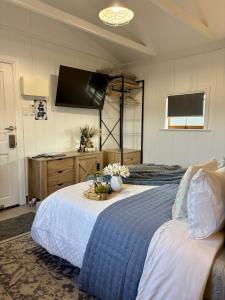 a bedroom with two beds and a flat screen tv at Edington on Mary - The Dairy in Gympie