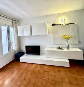 a living room with a white couch and a tv at Apartamento Tossa in Tossa de Mar