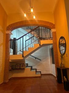 a spiral staircase in a house with a yellow wall at Quinta Pompella in San Salvador +31 photos