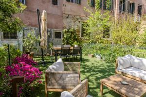 a garden with chairs and tables and flowers at Ca' de l'Astrologo in Venice