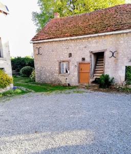 an old brick house with a door and a garage at Maisonnette Beauceronne in Eole-en-Beauce