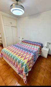 a bedroom with a colorful comforter on a bed at Apartamento Tossa in Tossa de Mar