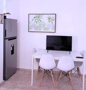 a white table with two white chairs and a refrigerator at Comfortable Apartment in the Greater Ponce Area in Ponce