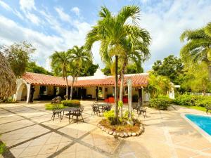 a courtyard with tables and chairs and a pool at Panáveda Ayurvedic Wellness Centre in El Creo