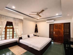 a bedroom with a bed and a ceiling fan at Maleyam Homestay in Kozhikode